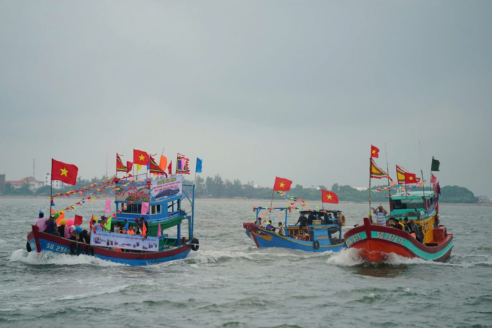 Fishing boats decorated with flags at sea during the Nghinh Ong Festival, Can Gio