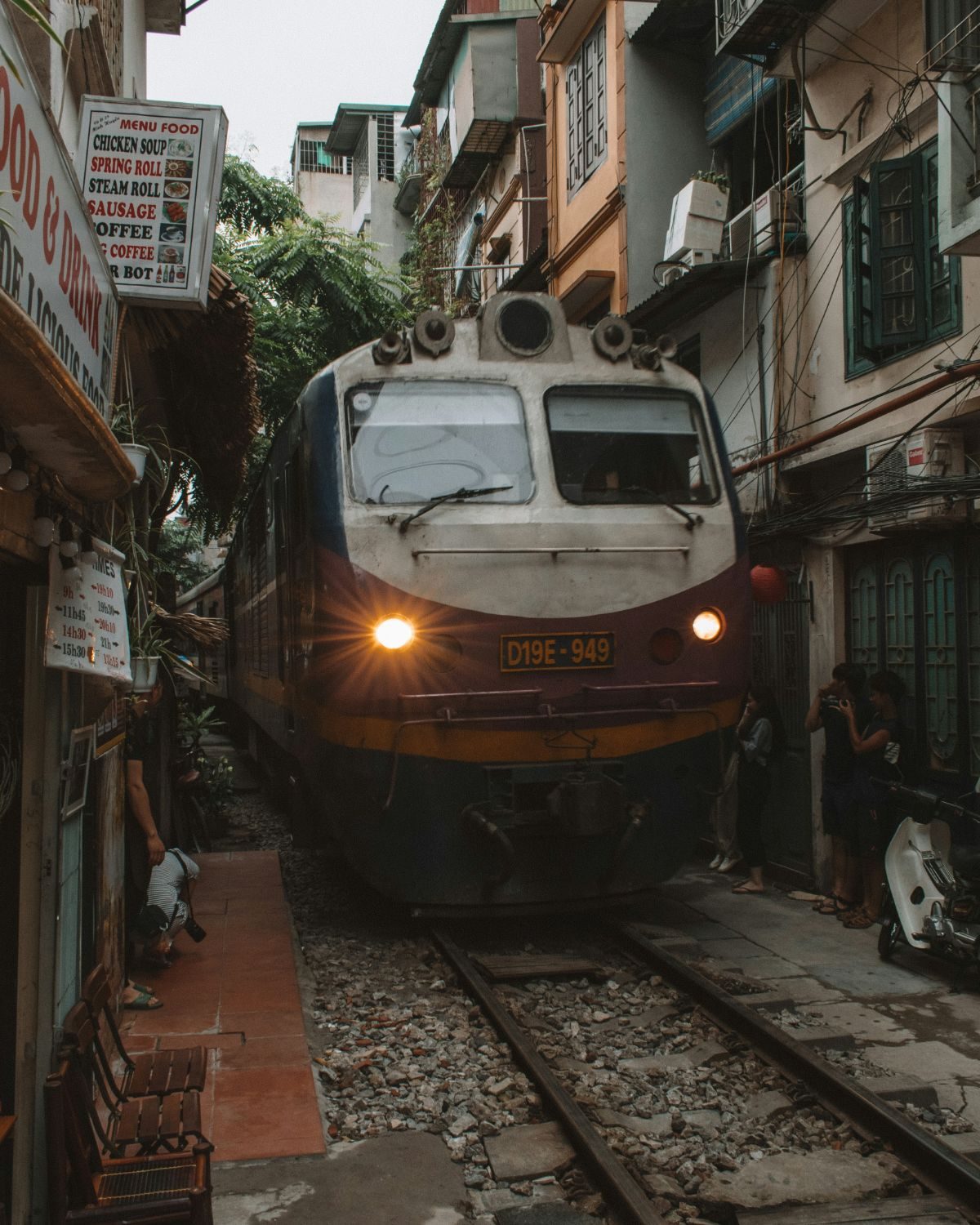 A train passing between houses and food stalls on Hanoi's train street