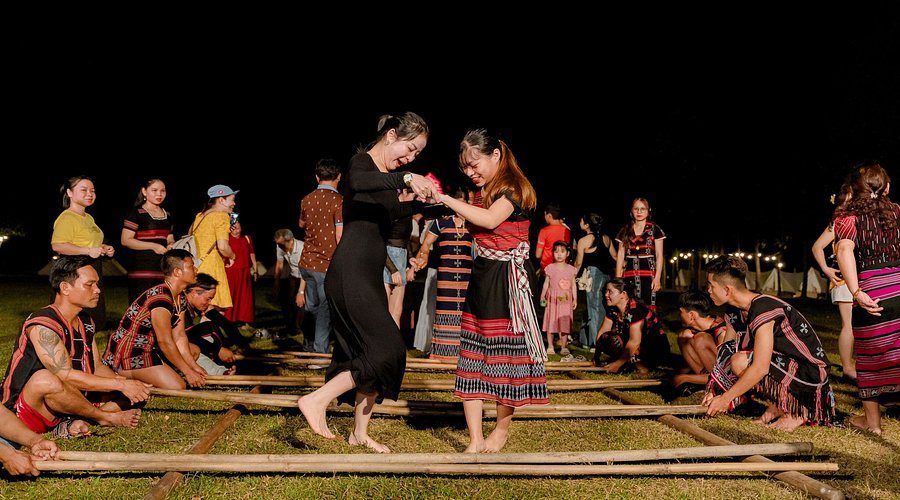 Co Tu villagers leading visitors in a bamboo dance at night in Toom Sara Village, Da Nang
